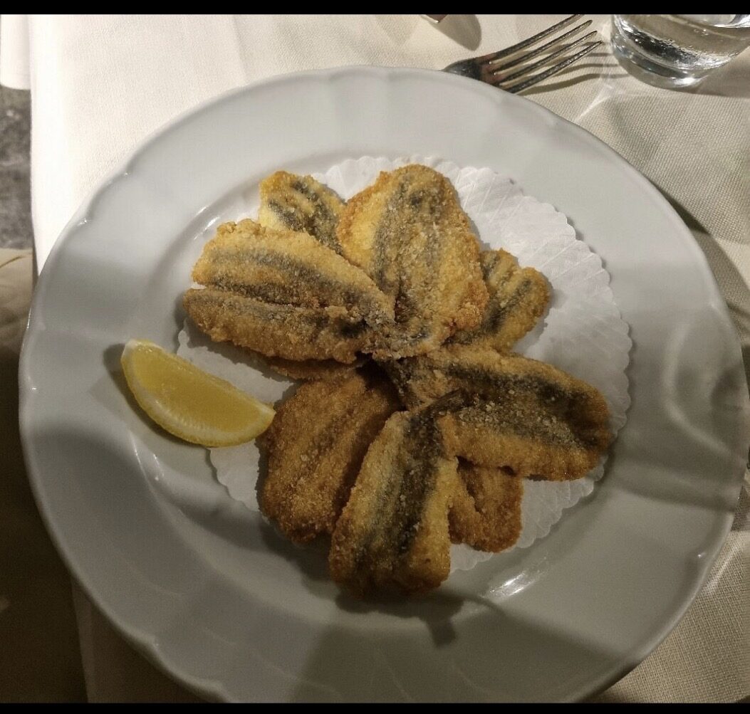 Acciughe fritte dorate servite con limone